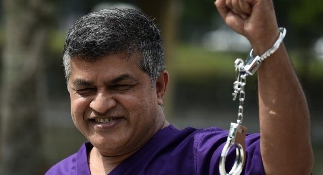 Malaysian cartoonist Zulkifli Anwar Ulhaque, popularly known as Zunar, poses with handcuffs prior to a book-launch event in Kuala Lumpur on February 14, 2015. Zunar, one of Malaysia's best-known political cartoonists, was arrested for sedition over a Twitter posting that criticised the jailing of opposition leader Anwar Ibrahim, the artist's wife said. AFP PHOTO/ MANAN VATSYAYANA