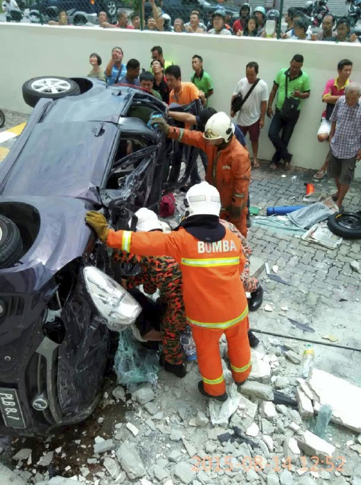 PENANG 14 August 2015. Anggota bomba dan penyelamat mengeluarkan mangsa pemandu kereta myvi yang terbabas dan terjunam dari tingkat tiga di Pangsapuri Taman Pekaka, Sungai Dua, Pulau Pinang. NSTP/Ihsan Pembaca
