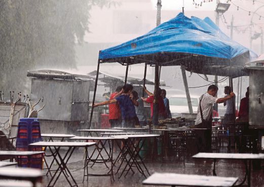 PENANG 08 August 2015. Orang ramai membantu memegang khemah peniaga di Pulau Tikus ketika hujang lebat dan angin kuat melanda beberapa kawasan sekitar Pulau Pinang NSTP/Mikail Ong