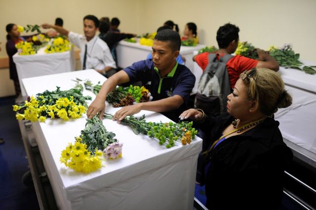 People place flowers on coffins of the remains of four Sekolah Kebangsaan Tohoi pupils, Haikal Yaakob,8, Linda Rosli,8, Ika Ayel,9, and Juvina David,7, who were reported missing on August 23 after fleeing from their hostel, at the Gua Musang hospital in Kelantan on October 25, 2015. The Malaysian Insider/Najjua Zulkefli