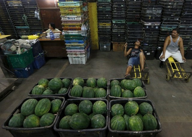 Workers take a break from unloading watermelon at a wholesale market in Kuala Lumpur, Malaysia, January 7, 2016. REUTERS/Olivia Harris